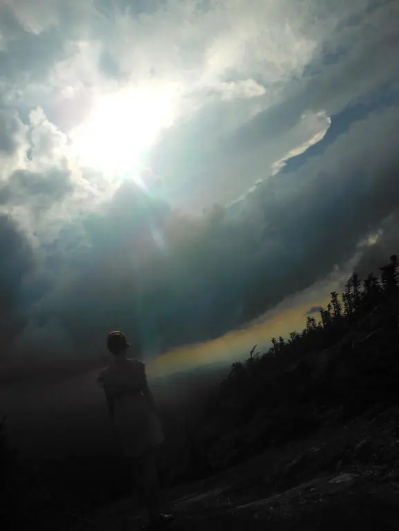 Individual gazing at sunlit cloudscape