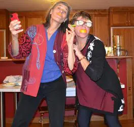 Two women posing playfully in kitchen