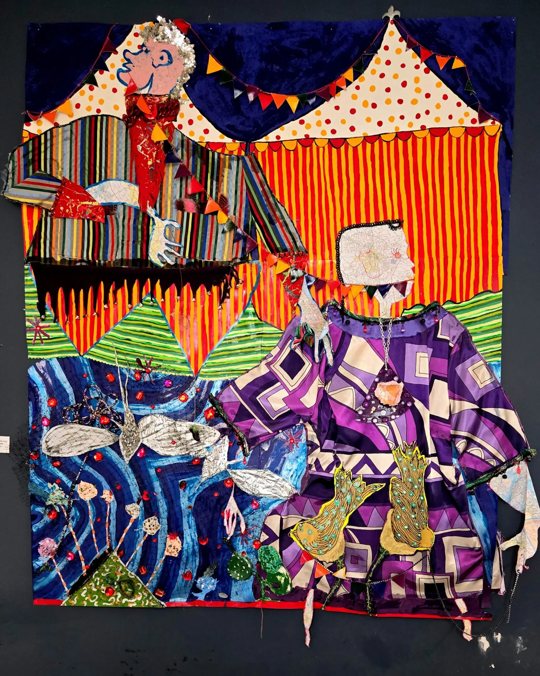 Colorful textile art depicting abstract figures in vibrant patterns.